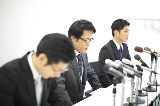 Three businessmen apologising