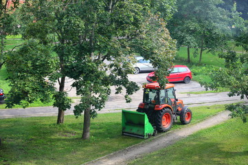The tractor collects the fallen leaves