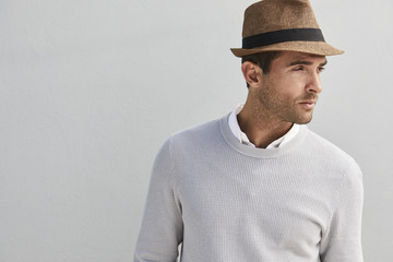 Handsome guy in grey sweater and hat, looking away - obrazy, fototapety, plakaty