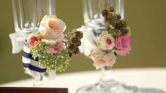 Wedding decorations for outdoor wedding ceremony. Glasses decorated with rorses and berries.