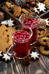 Christmas drink hot cranberry tea and cookies on dark background, vertical