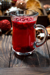 Christmas hot cranberry tea or mulled wine and assorted cookies on dark table, vertical closeup