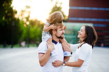 Cute young family on a summer day in the city square.
