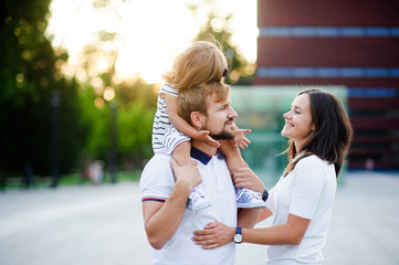 Cute young family on a summer day in the city square.