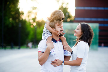Cute young family on a summer day in the city square.
