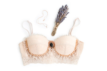 Glamorous stylish sexy lace lingerie with woman accessories on white background. Woman lace bra with dried lavender and necklace, flat lay, top view. Fashion concept, textile, jewelry, underwear.