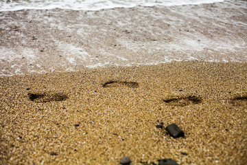 Child footprints on the sand on Black Sea