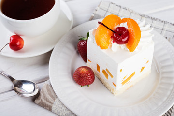 Tasty light cake with cherry on wooden table, holiday background