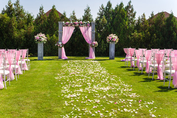 Tender pink and white wedding ceremony decorations on the lawn