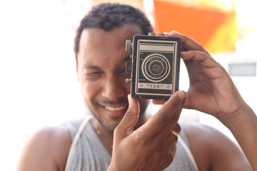 Young man holding vintage camera