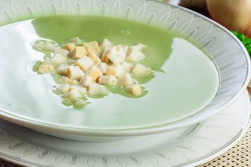 Broccoli cream soup in plate served with croutons