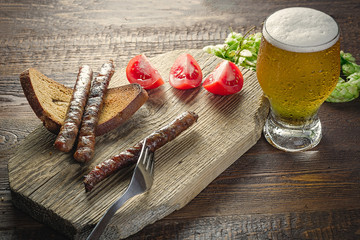 sausages with beer on wood cutting board.  Oktoberfest meal. 