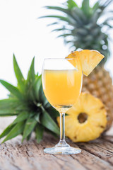 Glass of pineapple juice onwood table