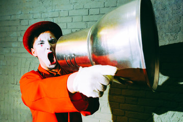 Mime took a metal lampshade and pretends to shout into the shout