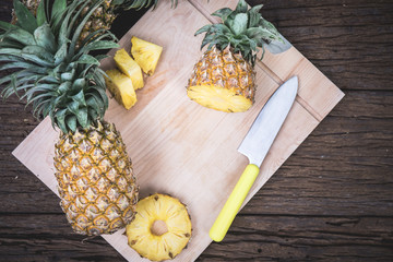 Sliced pineapple on a cutting Board with a knife