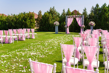 Tender pink and white wedding ceremony decorations on the lawn