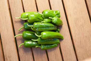 a pile of Pimientos de Padron on a wooden Table