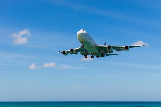 Airplane Landing Above Beautiful Beach And Sea Background