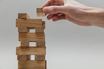 Male hand stacking wooden blocks. Business development and growth concept