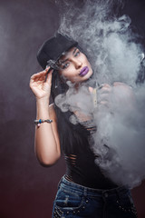 Young sexy woman is vaping. A cloud of vapor. Studio shooting.