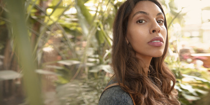 Beautiful young multicultural woman in tropical city park.