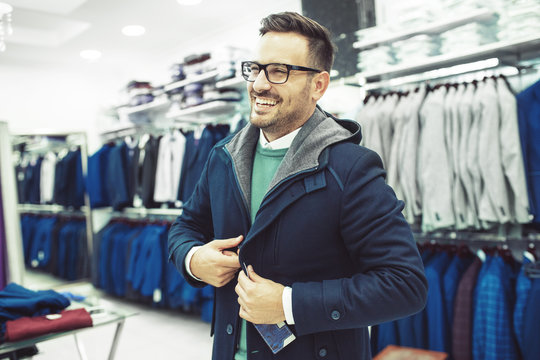 Smiling Young Man Buying Jacket for Autumn