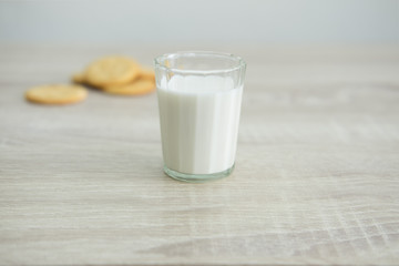 MILK AND CRACKERS
A glass of milk with pile of crackers on the wood top table. 