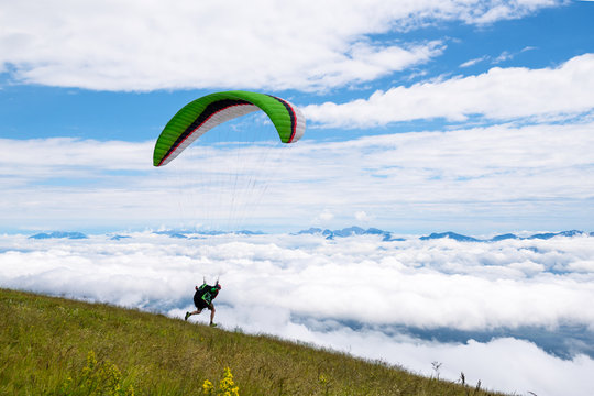 Paraglider beim Start &uuml;ber den Wolken in Gerlitzen