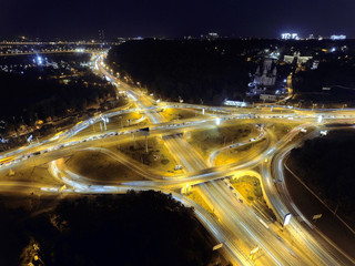 Fototapeta na wymiar Vertical top down aerial view of traffic on freeway interchange at night