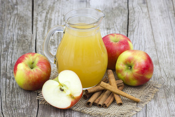 Apple juice and apples on wooden background