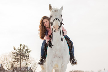 Nice girl and white horse outdoor in snowfall in a winter - obrazy, fototapety, plakaty