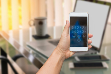 Close up hand holding smartphone while entering the passcode.