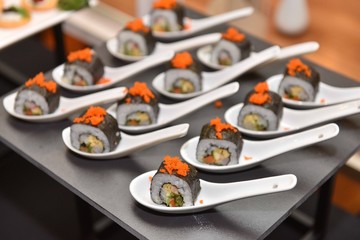 Food : Japanese rolled sushi slice and place on spoon. Prepare for service in Japanese buffet party...