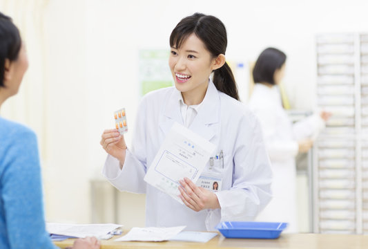 Female pharmacist talking with customer
