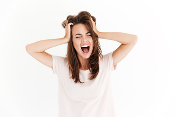 Screaming brunette woman in stress holding her head
