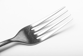A single silver fork on a white background showing regular wear and tear