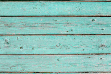 Wooden texture of turquoise color. Old painted fence of boards.