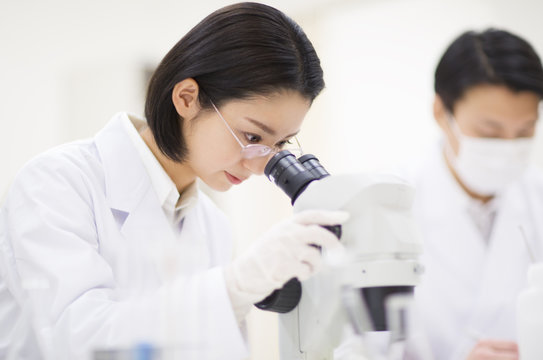 Female scientist using microscope