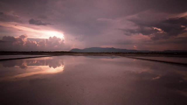 Mirror image cloud reflections on the salt fields of the south east Asia Monsoon season with stunning sunset