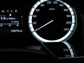 Mobile phone indicate reflection of car speedometer 
