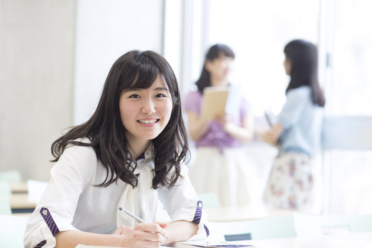 Cheerful student in classroom sitting at desk