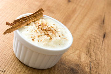 Arroz con leche. Rice pudding with cinnamon on wooden background

