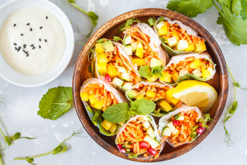 raw spring rolls with vegetables in a wooden bowl