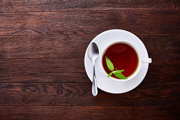 Green tea with lemon and mint on wooden table background