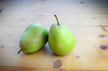 Ripe organic pears on a wooden table, top view.