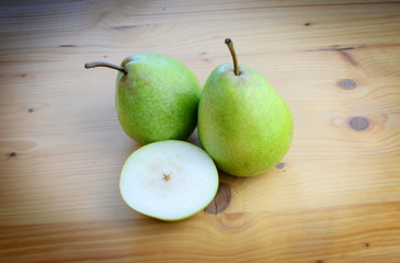 Ripe organic pears on a wooden table, top view.