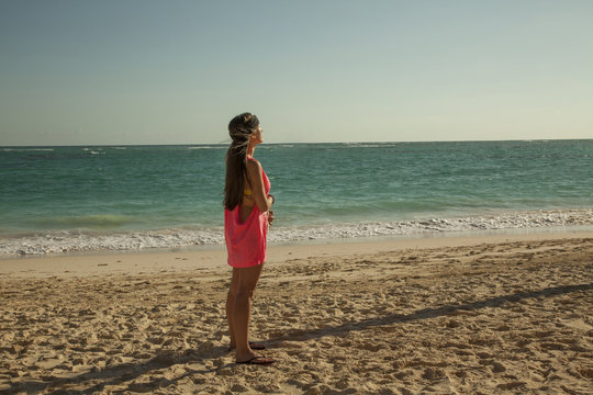 Beautiful woman standing up in the sun. Tropical caribbean beach.