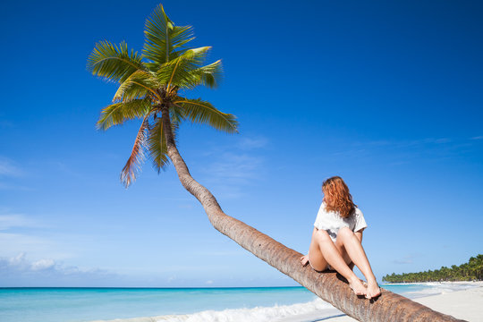 Teenage Girl Sitting On A Palm Tree. Saona Island