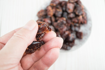 Hand mit getrockneten Cranberries, Holzhintergrund