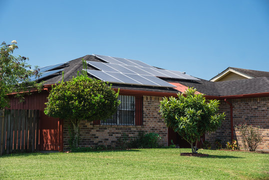 Close-up Solar Panels On The Gable  Roof Suburban House Under Blue Sky. Photovoltaic Solar Collector For Renewable Clean Green Energy, East Of Louisiana, USA. Sustainable, Efficient Economy Concept.